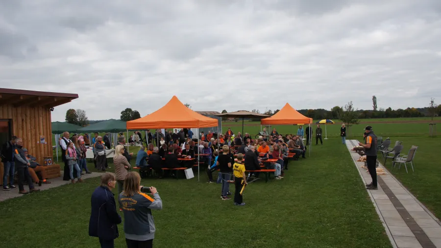 Viele Gäste unter orangen Zelten